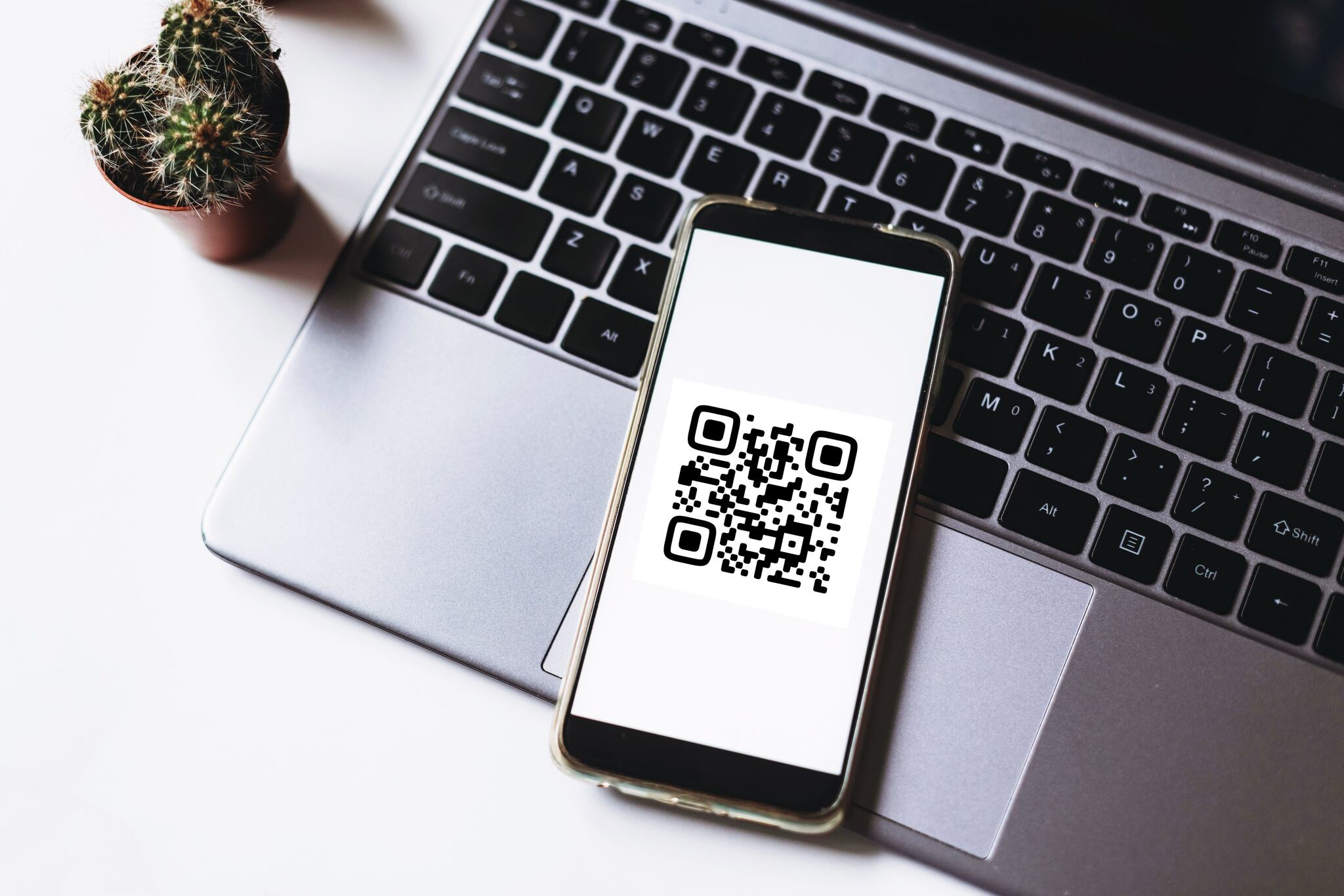 Smartphone scanning a property listing QR code displayed on a computer screen