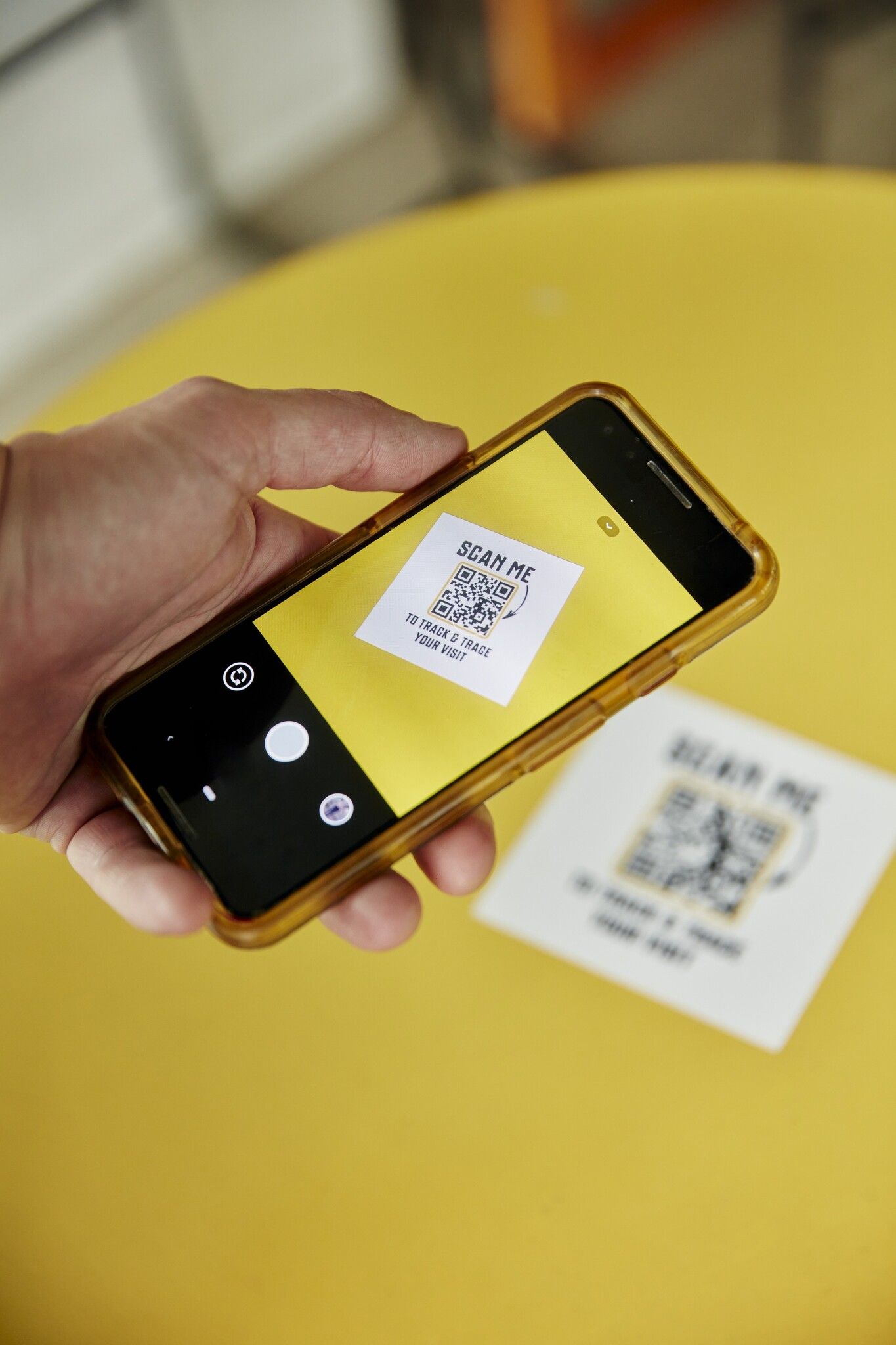 Hand scanning a track and trace QR code at a property viewing