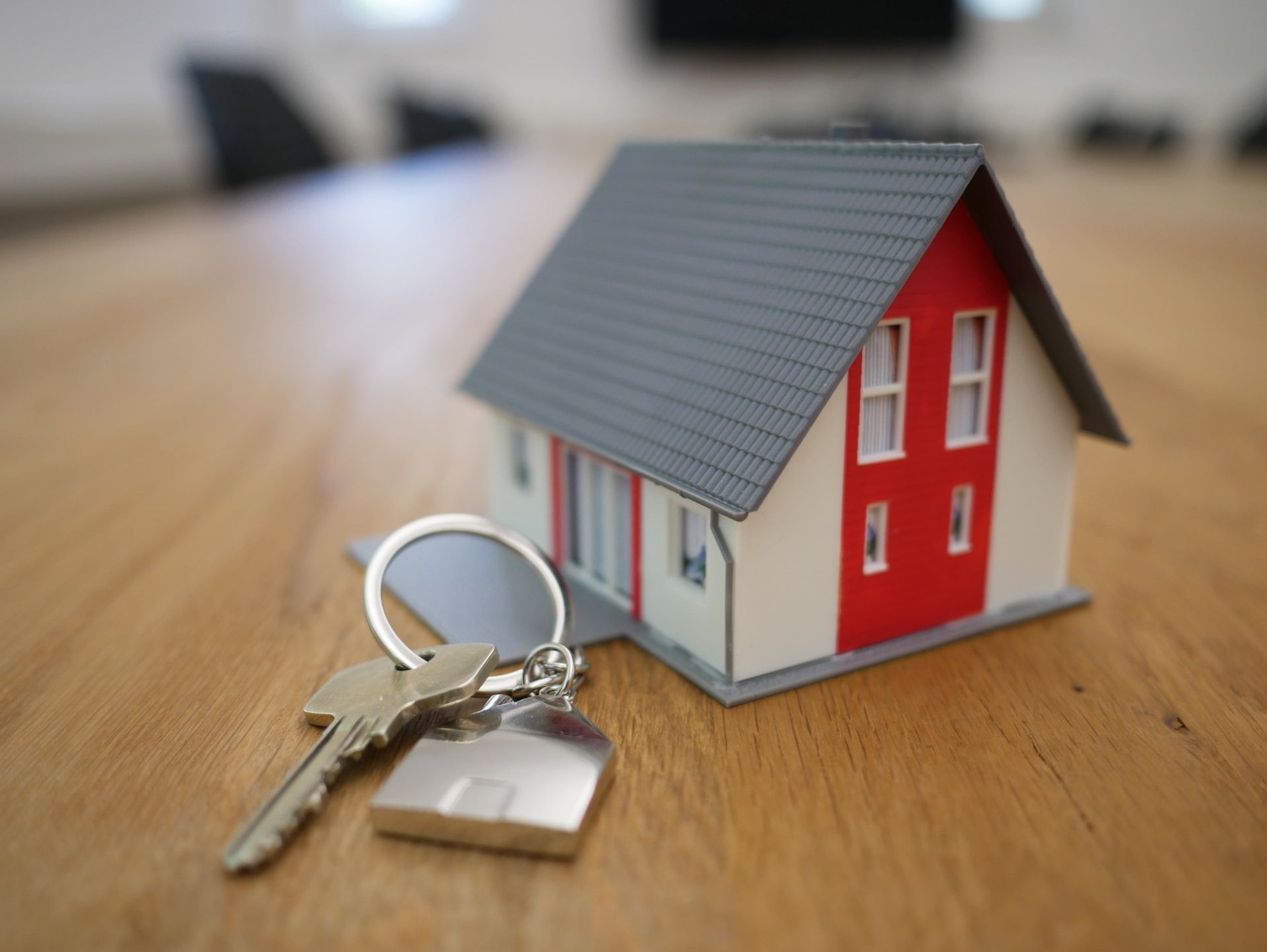 Wooden model house with house keys representing real estate closings