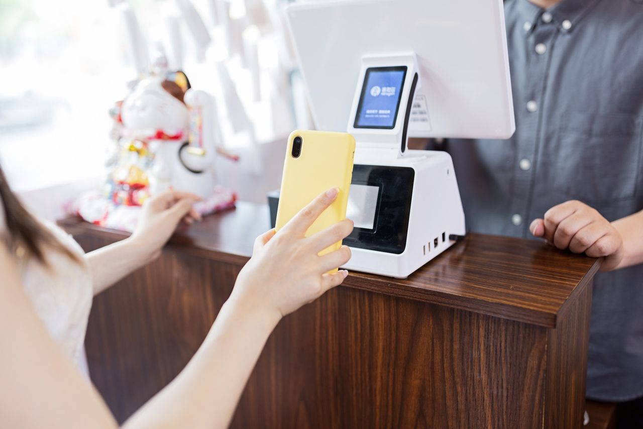 Woman scanning a retail QR code with a phone in a yellow case