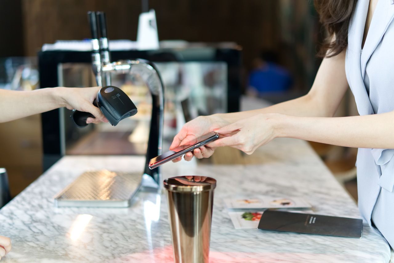 Close-up of a customer scanning a receipt QR code with a smartphone