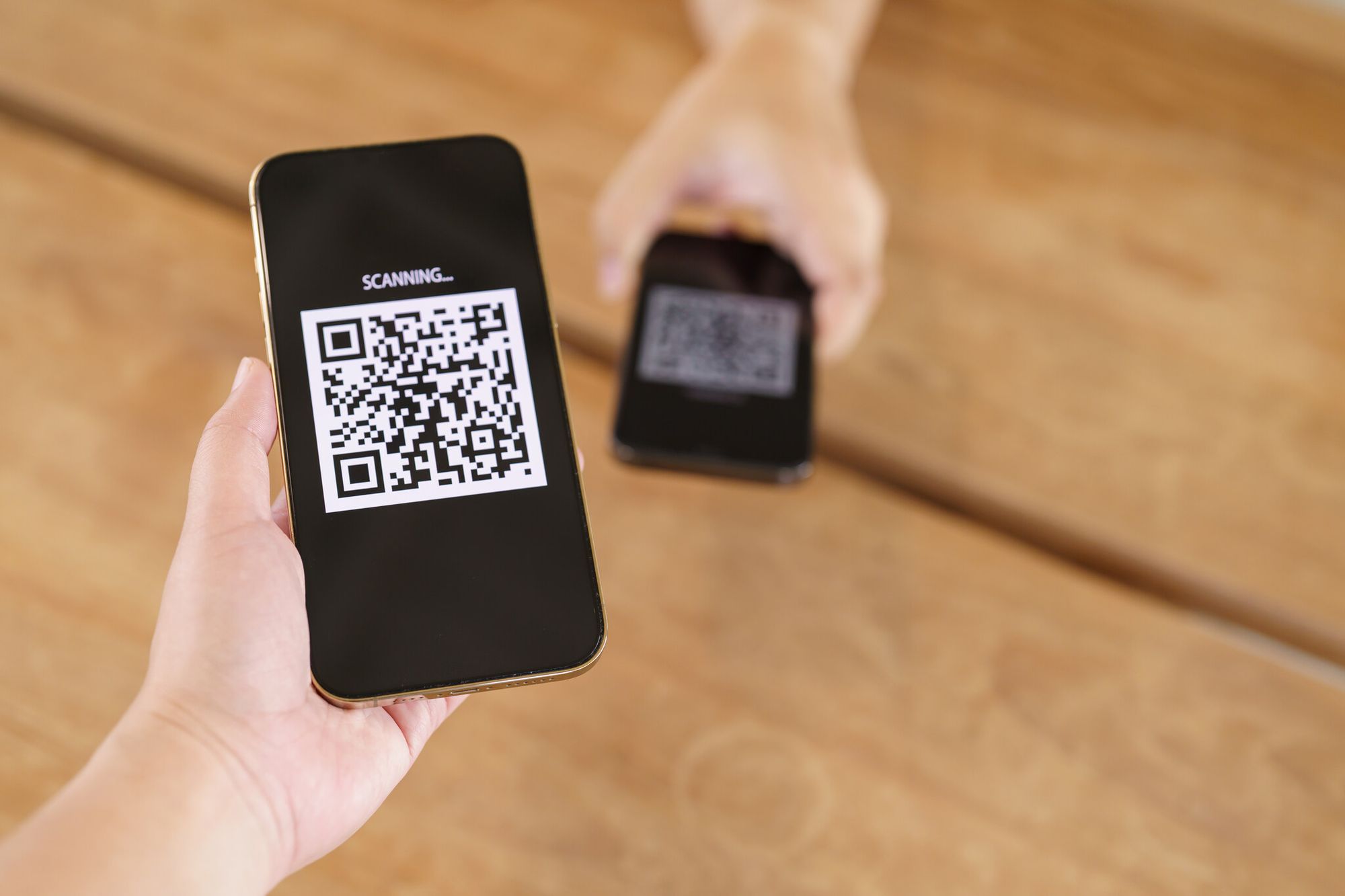 Man scanning a retail QR code displayed on another phone