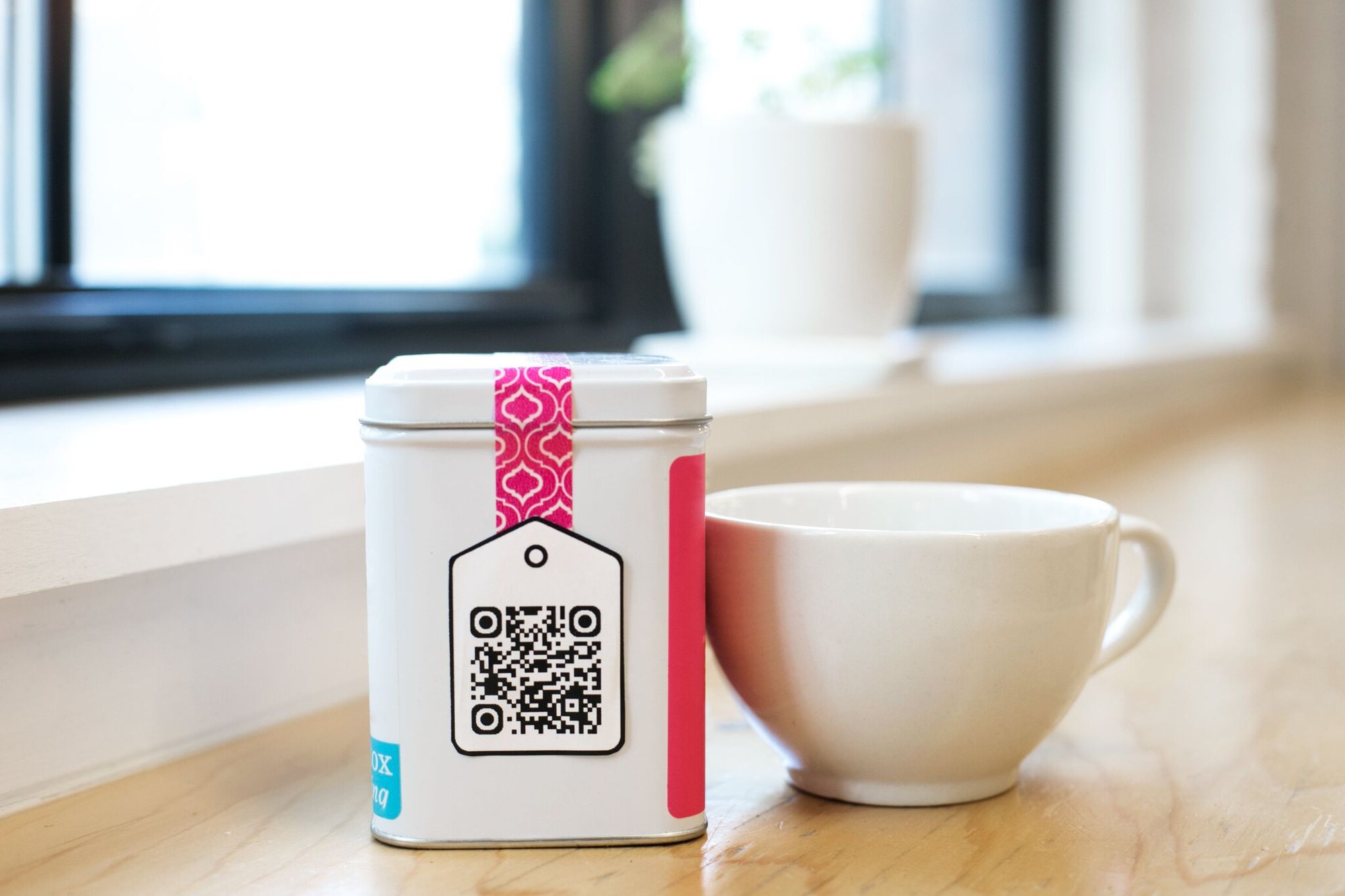 QR code printed on a tea box next to a mug