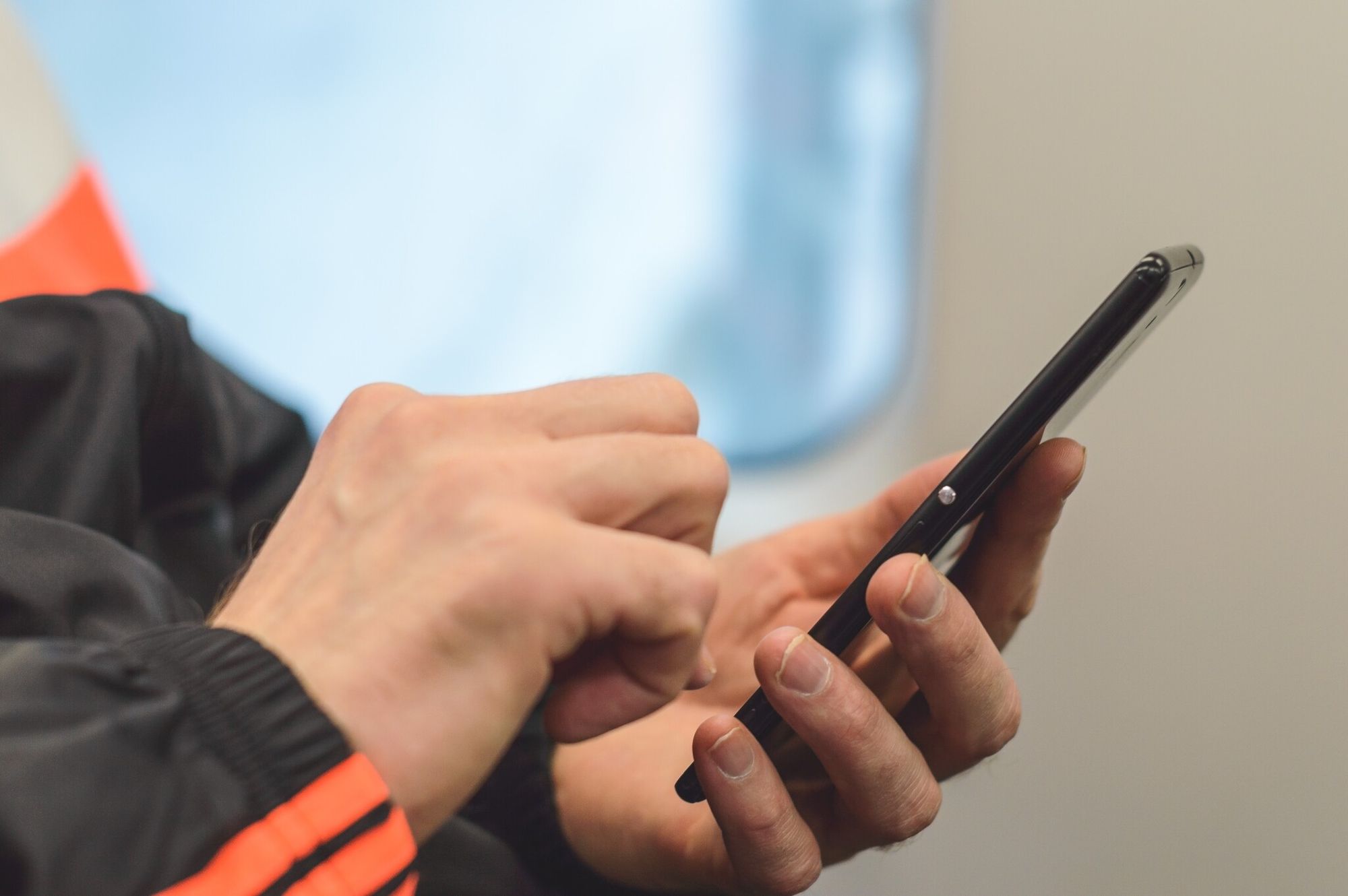 A hand holding a phone checking a QR code link before scanning
