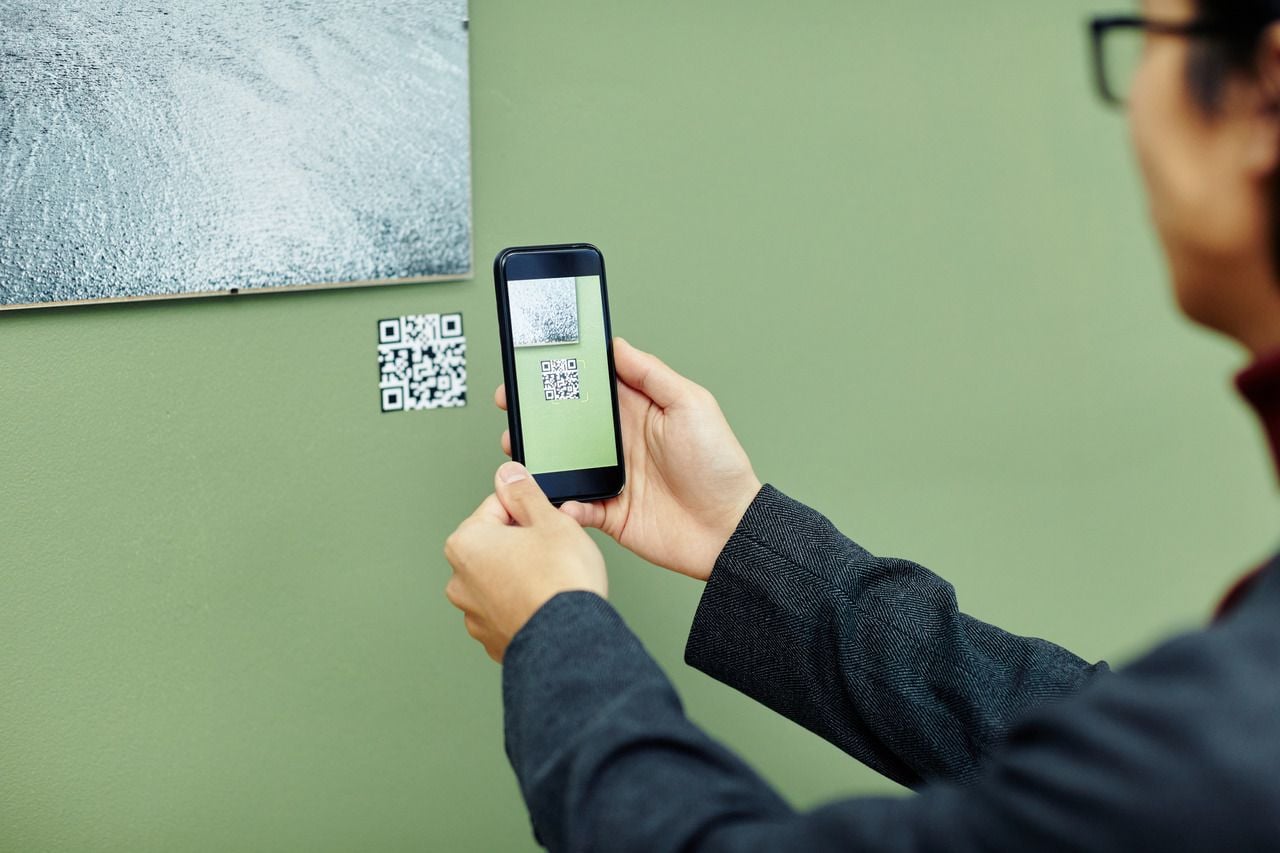 Student scanning a classroom QR code with smartphone camera for instant resource access