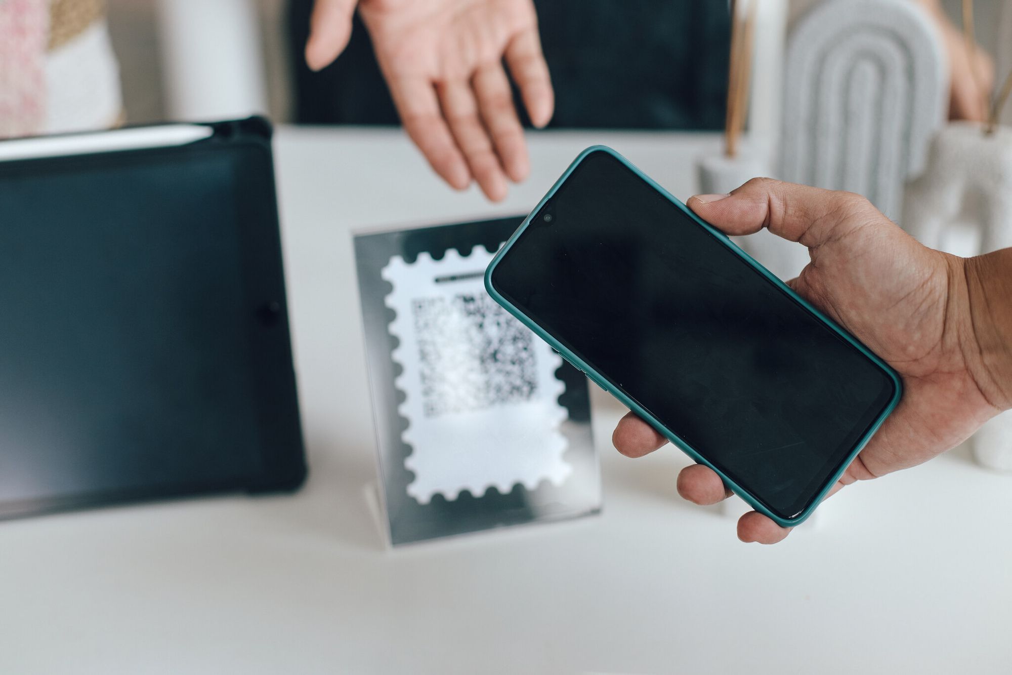 Smartphone held in front of a dark QR code pattern illustrating app download security checks