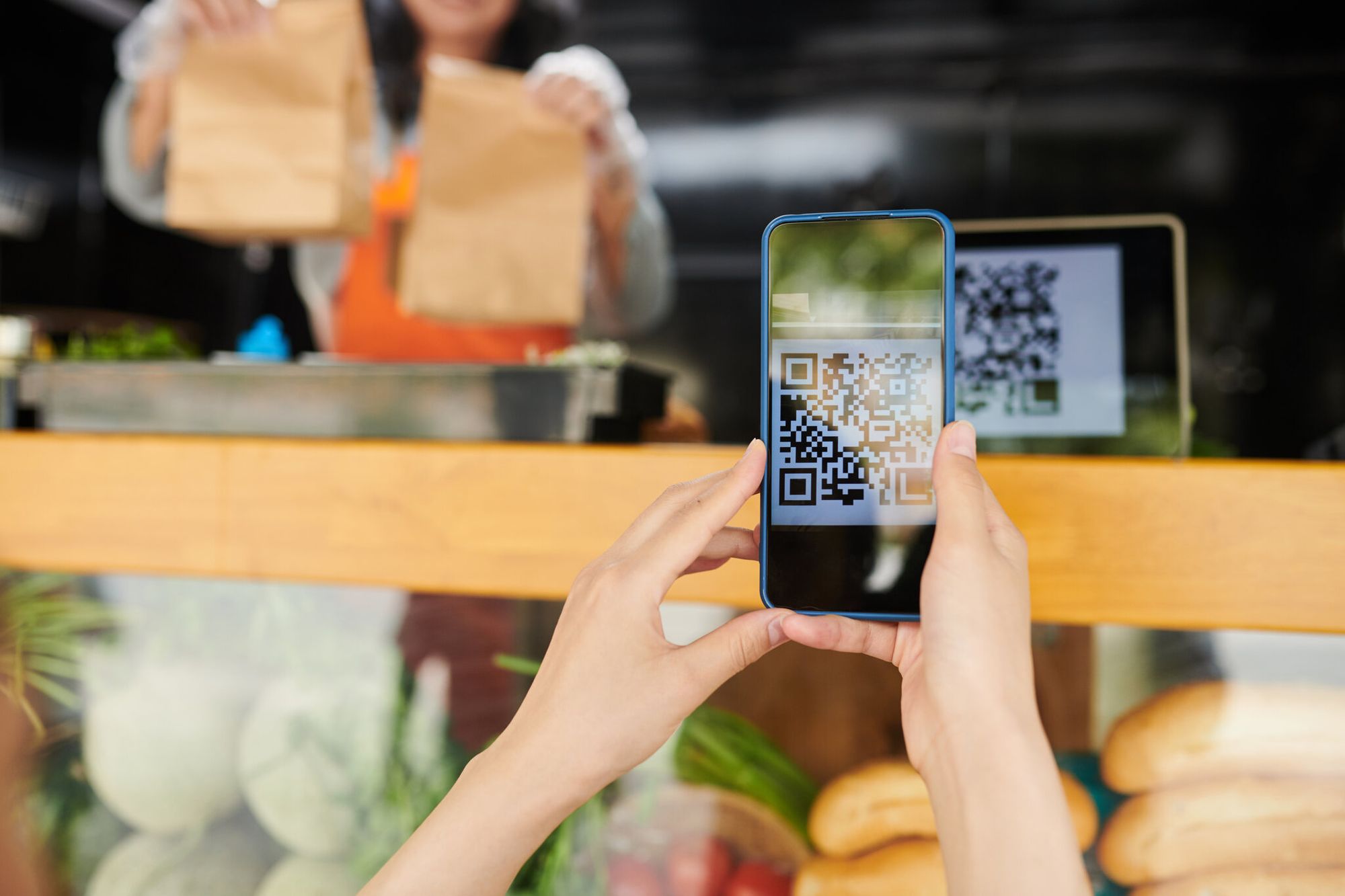Hands of a female retail customer scanning a QR code near a product display for app install