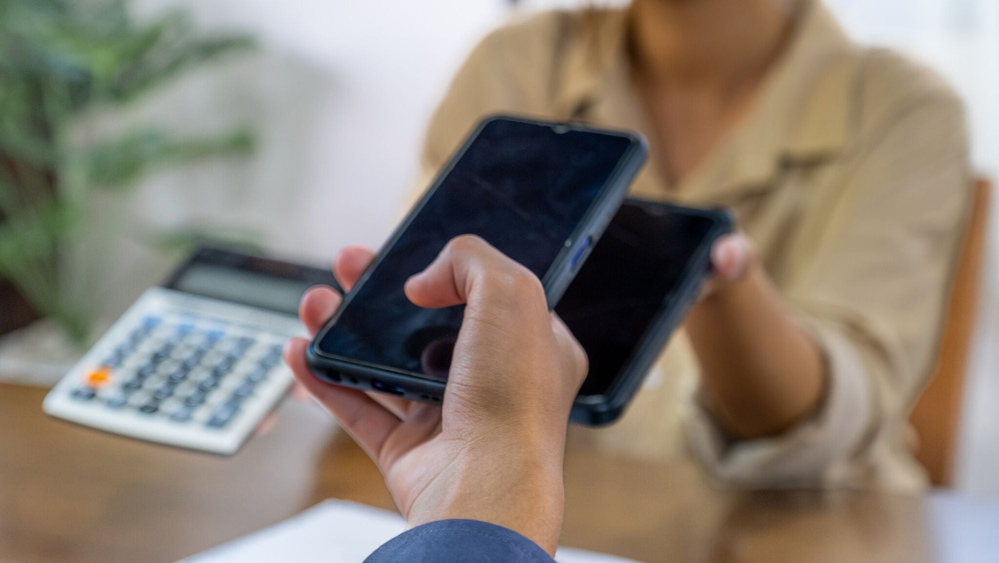 a hand scanning QR code from another phone