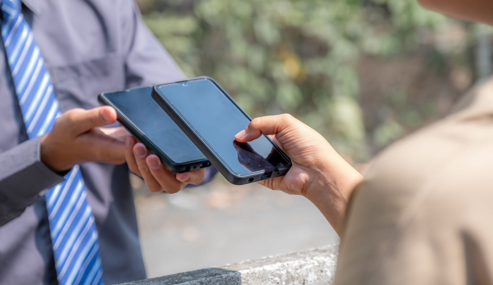 a hand scanning a QR code from another phone
