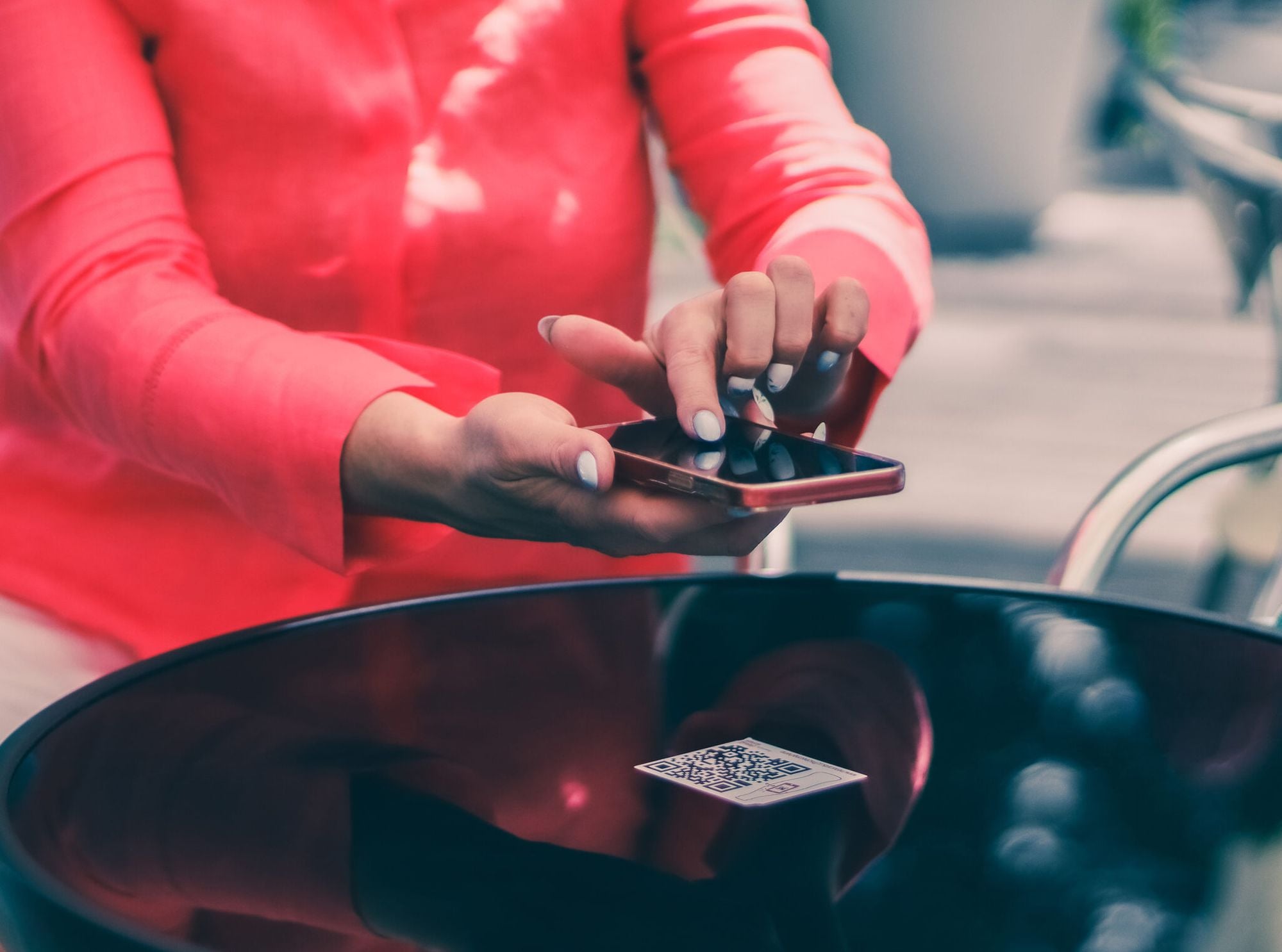 hands of a young woman scan the QR on table