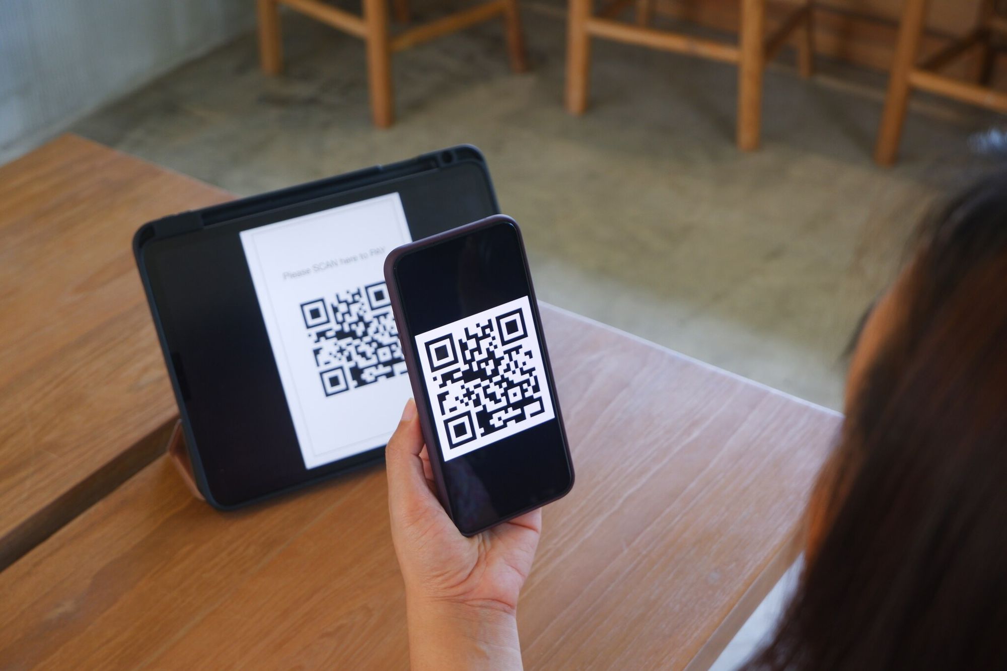 a hand scanning a QR code