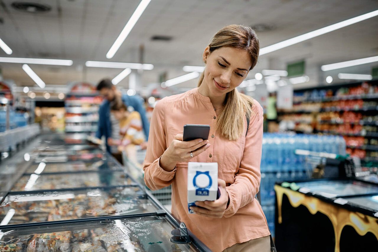 smiling woman scanning a QR code on a product