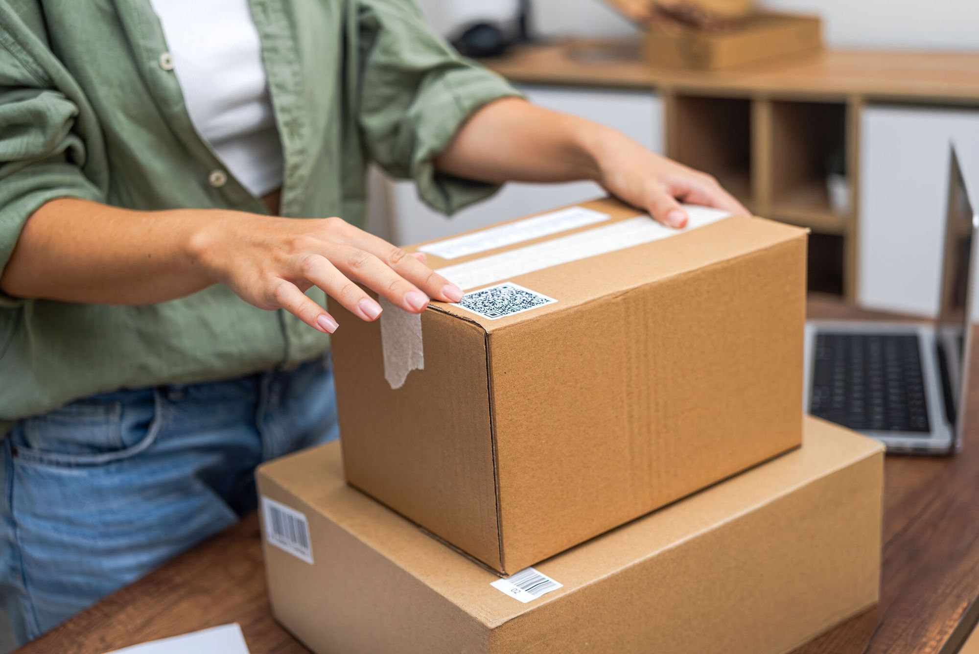 woman hands attach QR code to package